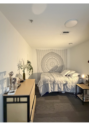 Bedroom including dresser and nightstand. - South Campus Commons 1 Apartments