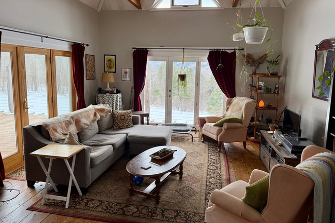 Shared living room (with current tentant's furnishings; will be different furniture, modern artwork, etc.) - Private Room and Shared Kitchen/Living Space in Peaceful Setting House