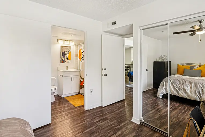 Bedroom, you can see into the bathroom and the bed in the closet reflection. The desk is just out of frame to the right. - Lexington Crossing Apartments