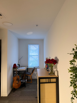 Bedroom facing window with desk. - South Campus Commons 1 Apartments