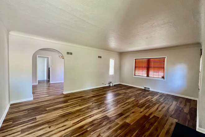 Living Room - Charming 4BR/2BA brick home with arched entryway located one block from DU. Available Sept 1, 2025