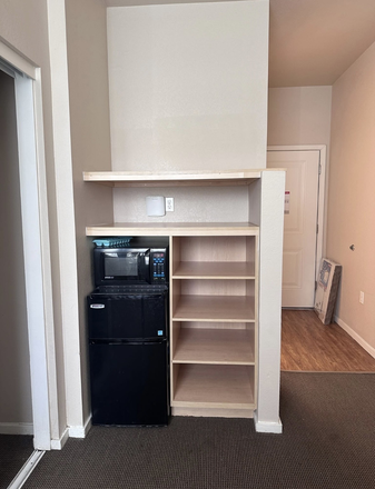 Included mini fridge/microwave with extra storage space - The Suites Apartments