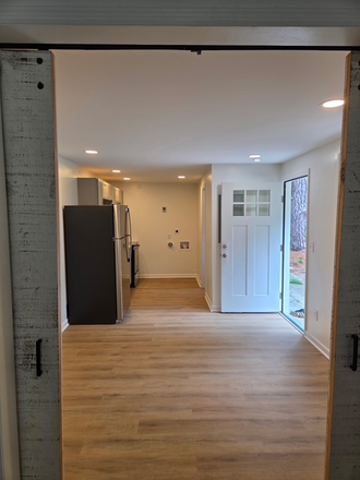 View of the living area, kitchen and entrance. New stackable Washer/Dryer now installed on the back wall. - Charming 1BR Near Downtown Charleston & MUSC | Walk to Greenway Duplex