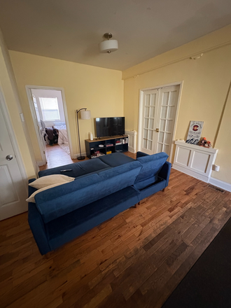 living room, door on left is the door to the basement/storage room - Blue Dream House