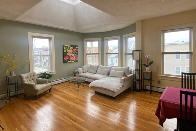 Spacious living area with expandable dining table - Fully-furnished Inman Square Condo for Summer Rental