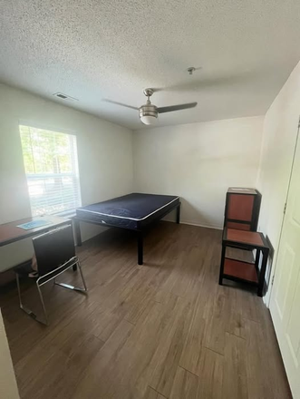 Bedroom furnished with a full sized bed, desk, chair, side table, and dresser. - University Walk