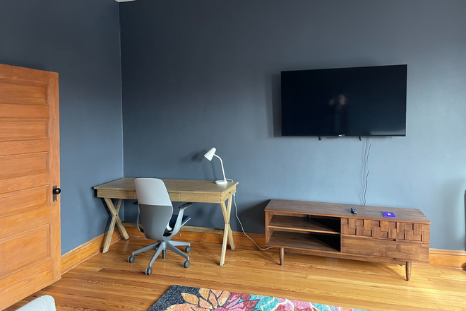 Living room photo 3: TV, desk, and ergonomic Steelcase chair - Furnished apartment in historic row home, including utilities+internet+cleaning (1 b