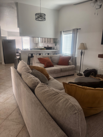 living room with comfortable couches and view of kitchen with barstool chairs - Afforadable UCR Off Campus Housing- W/ Kitchen +Parking House