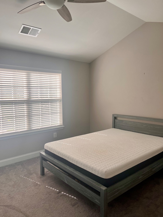 Bedroom with large en suite bathroom and walk-in closet, dresser, nightstand, wall of windows and ceiling fan. - Master Bedroom with en suite bathroom and walk-in closet close to UMD campus