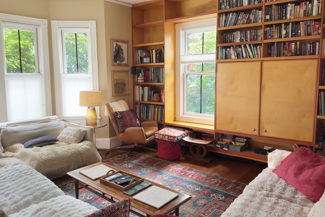 main living room, couches face wall of books and large screen TV (behind cabinets) - Furnished 6BR Victorian | Off Brattle St | Parking | Sept 2026–May 2027 | Utilities Included