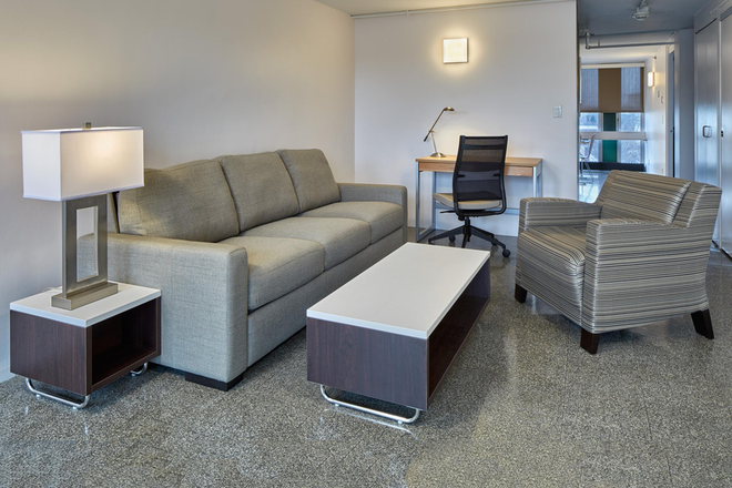 Sample furnished living room at Peabody Terrace – sofa, coffee table, balcony access - Summer Sublet – 1 Bedroom in 2BR Peabody Terrace Apt, Utilities Included