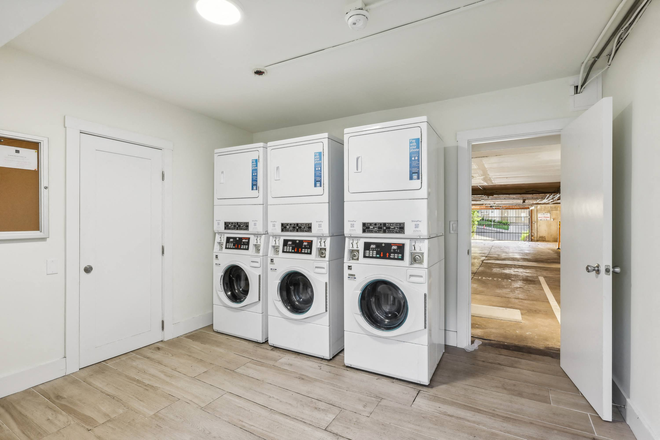 Laundry room with washing machines neatly arranged on a wooden floor - 2369 Le Conte Avenue