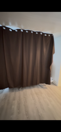 The right side of the wide and dark curtain that isolates the livingroom/bedroom from the rest of the unit - The Boulder (female only)