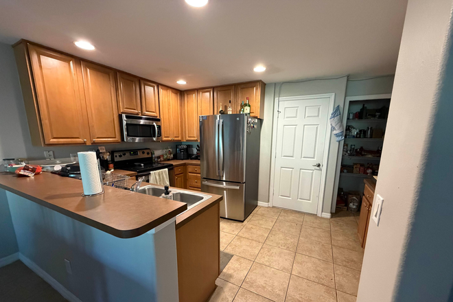 Fully furnished kitchen with pantry and garage access - Hawthorne Glen Apartments