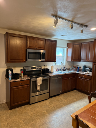 Kitchen cabinets with electric range - 4 BR Fully Furnished Townhouse in quiet, tree-lined Pheasant Run neighborhood near Va Tech