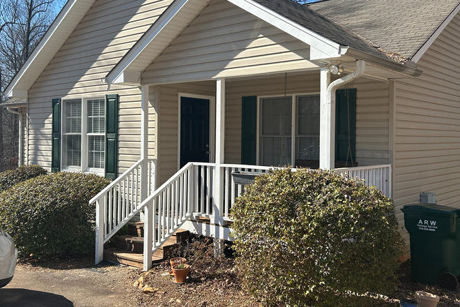 Front of House with porch swing - Four bedroom Home 10 min. from campus w/one basement suite w/private bath available as of 5/1/25