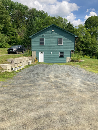 Side view of house with upper and lower parking areas - 3 BR House on 38 acres with pond, privacy, easy 10 minute commute to VLGS