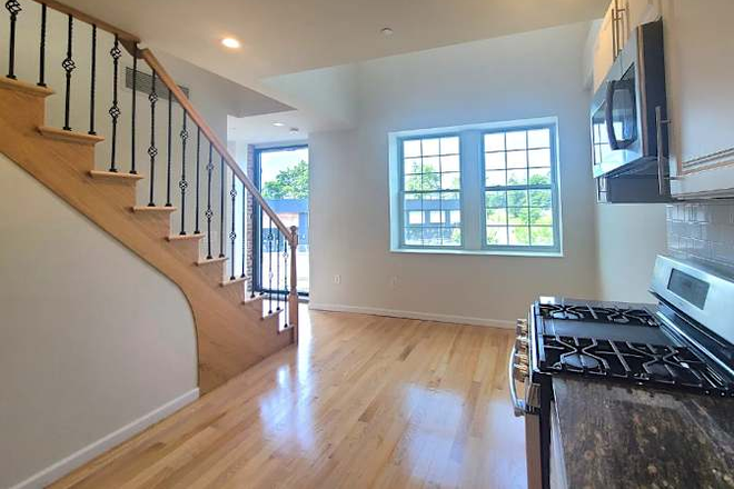 duplex: kitchen, eating area. washer dryer under stairs - Bright room, private bath in shared apt. in New Brunswick