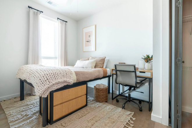 Fully furnished bedroom with full sized bed, dressers, desk and chair and closet. - Sweetwater Apartment