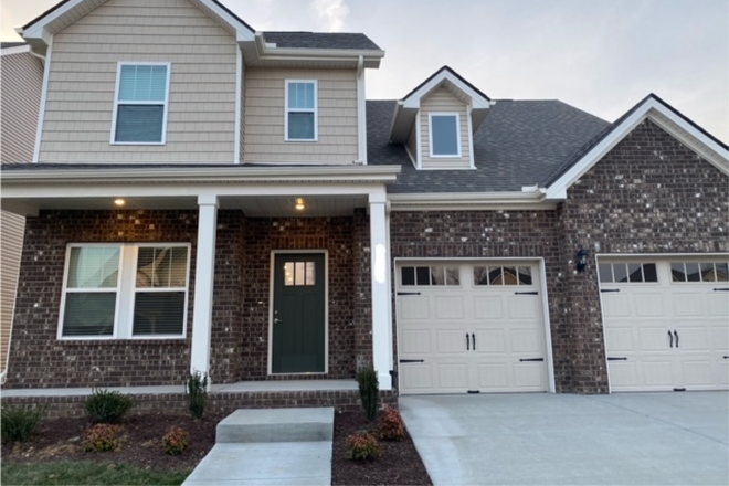 Front of house. Patio seating. 2-stall garage. - New home in quiet neighborhood