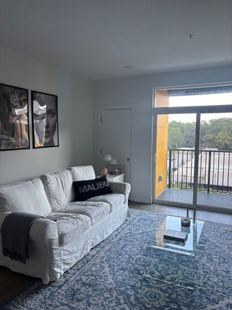 Living room with balcony overlooking the pool, furnishings not pictured. - Current Midtown Apartment Top Floor/Main Building