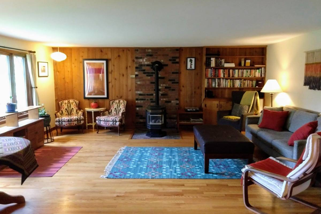 The "Great Room" includes an electric "wood stove" for cozy ambiance. Love set of tall windows facing the street. - Lovely home in Northampton, 18 minute drive to UMASS