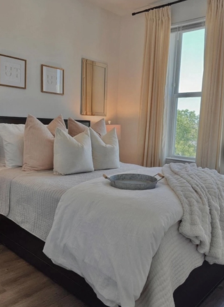 Bedroom with furnished bed and under bed storage - Flagship Kerns Apartments