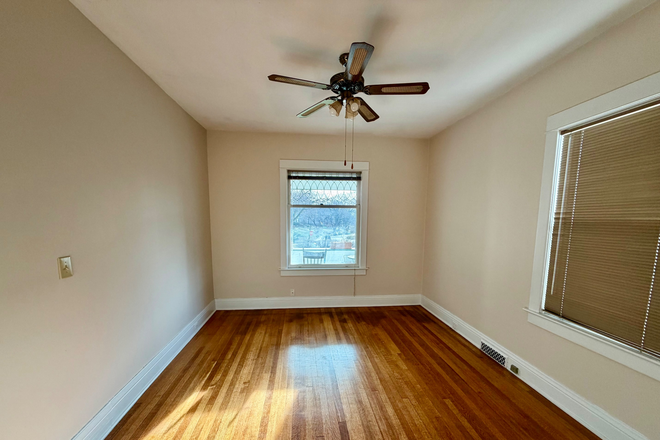 bedroom with original hardwood floors and park view from the window - 3BR Apartment in Triplex - Historic Park near Universities, Downtown/Midtown/Blackstone