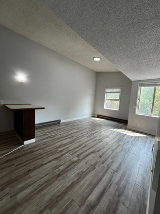 Open-concept living space with easy access to the kitchen. Perfect for roommates or entertaining. - 1414 Alder | 2 Minute Walk to UO Campus, Parking Included | $1,000 Cash Move-In Bonus Apartments