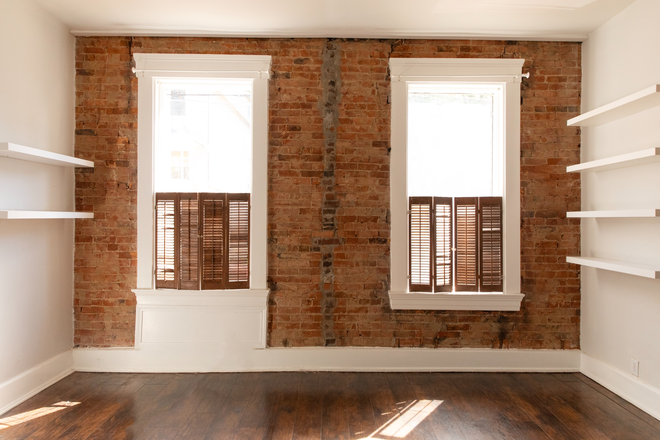 Living room/bedroom facing the front (Winkler street). Floating shelves offer unique design and plenty of book/ plant storage - 124 Winkler Street Unit #1 Apartments