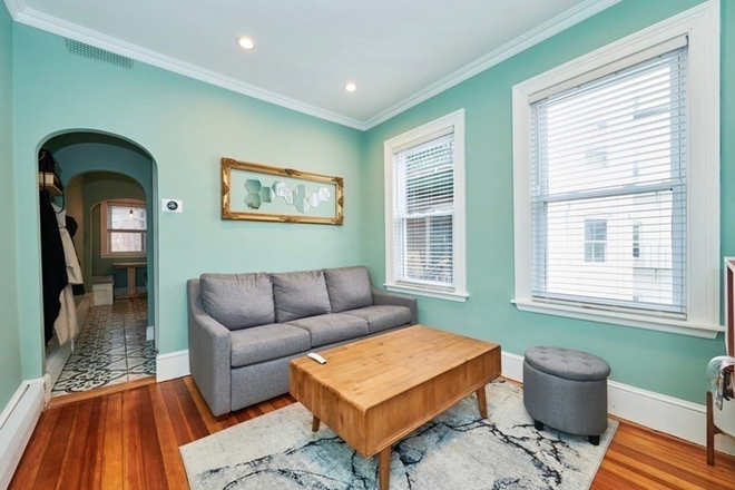 Living room with comfortable pull out couch and coffee table - Charming fully furnished 1 bedroom apartment in Mid Cambridge