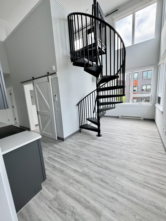 View of staircase up to loft, kitchen (left) and downstairs living area - City Sunrise 307 | Lofted 2BR, New Build w/ Amenities | 1 Month Free Rent if signed by 9/1