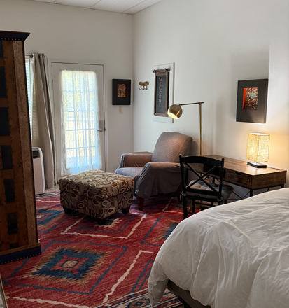 Main area of appt. desk, bed, comfy chair - Paper Cat Retreat and Studio