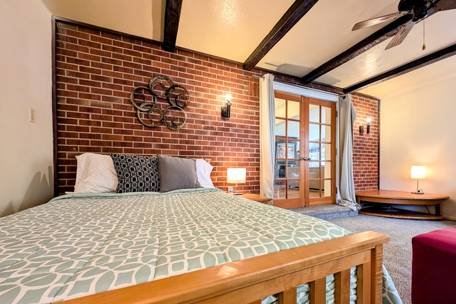 Upper level, Bedroom 3, largest of the 3 bedrooms, exposed brick walls and newly installed carpet - Furnished 5BR/2BA Duplex (2 Private Entrances) near Regis. WiFi & utilities incl. No pets/smoking. House