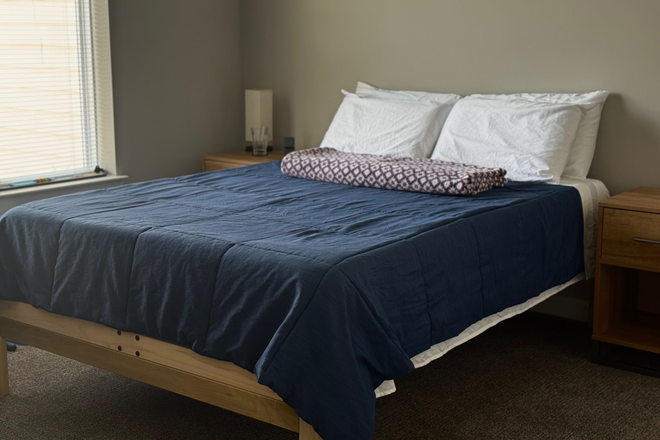 Bedroom with open window and furniture (will be removed prior to sublet start) - Entire 1 bedroom at Vue, Winter through Summer Apartments