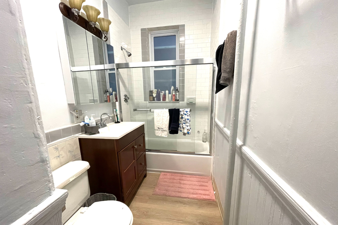 Modern renovated bathroom with toilet, sink and bathtub with sliding glass doors - Large apartment in very good condition within 10 minutes walk to Northeastern and Berklee