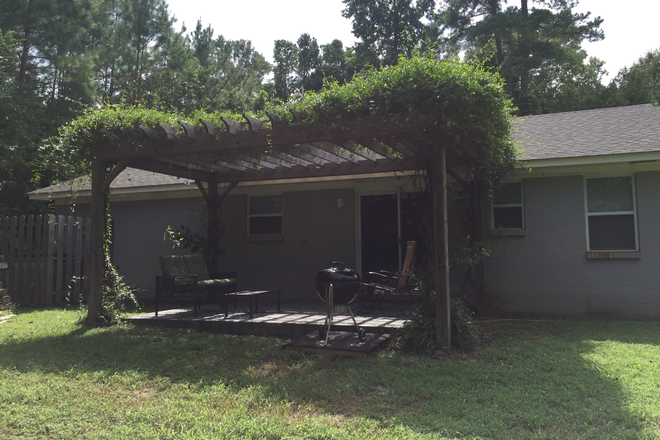 Flower bed behind A/C on left, Tree line  across CR in front - Cottage-style house just off Highway7S in private, wooded area