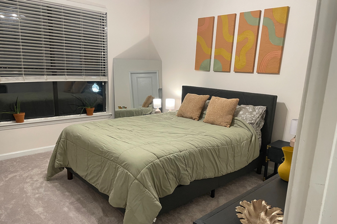 Large bedroom with queen bed, two nightstands, shelves, desk, & chair - Furnished primary suite in a vibrant condo with direct beltline access