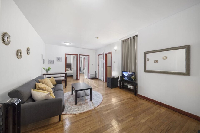 Living room, fully-furnished with couch and TV - Newly Renovated & Fully Furnished 3 Bed/1 Bath Near BU Med/BMC