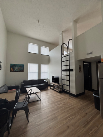 Main living area with dining room table, all furniture (not TV) included, with ladder up to the very spacious loft. - Yugo River West 2 Bed 1.5 Bath Loft, Summer Rental