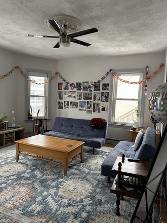 large living room, lots of natural lighting - 4 windows, TV and two futons - Mission Hill 3BR/1BA – One Room Available in Newly Renovated, Sunny Apartment