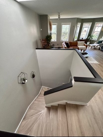 Stairs from the first floor to the main floor with the living room and kitchen - Spacious close to campus two story apartment, private room sublet with option to extend lease