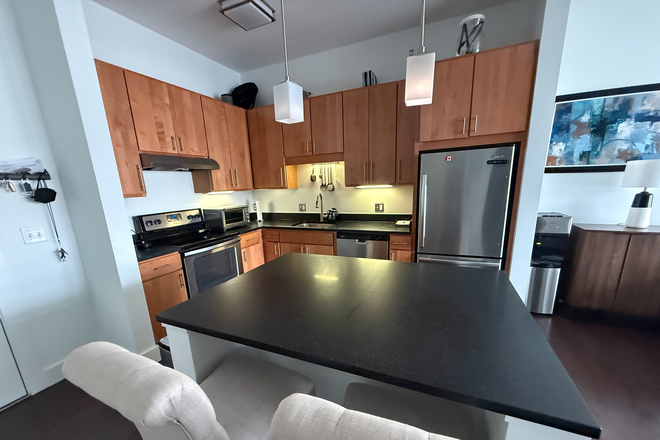Ample cabinet space + kitchen islnad - Quiet Top-Floor 1BR | In-Unit Laundry, Fireplace | Shuttle to Red Line Apartments