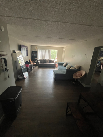 Living room is our most shared space. We have a dining table, bookshelf, and couch that converts to pull out bed for anyone to use. - Harbor Point on the Bay Apartments