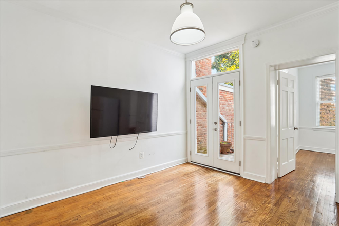 Living Room with door to private balcony - 2BD/1BA in Historic John Casey House