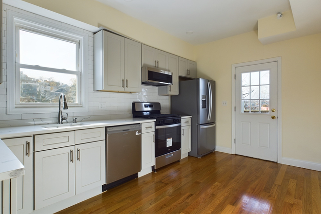 Kitchen - Modern 4BR/2BA: Central Air + In-Unit Laundry + Private Deck Apartments