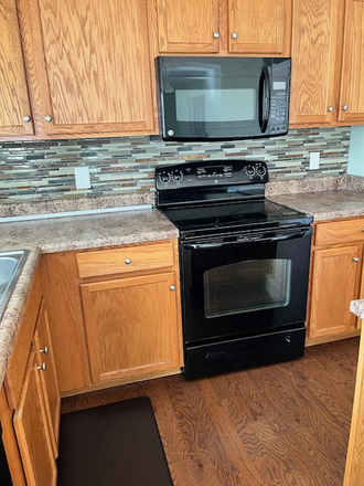 Kitchen with built-in large capacity microwave and like-new range - The One House